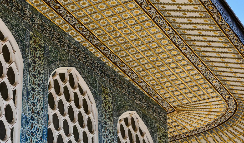 a close up of a tiled building with large white latticed windows